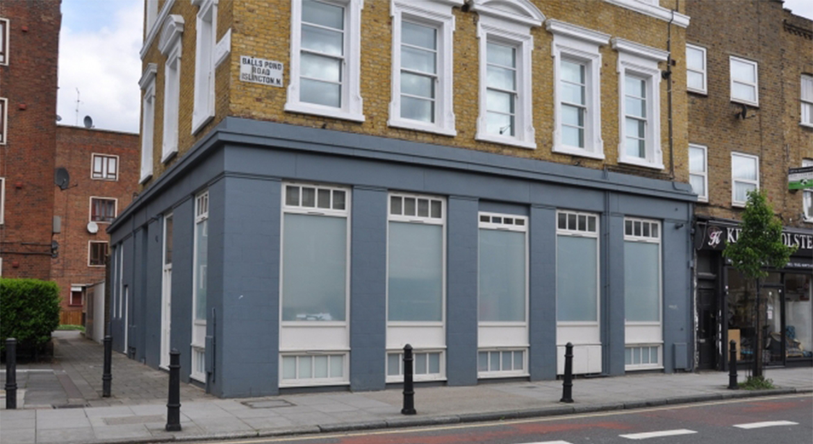 Windows, doors, and shopfront on a building on Balls Pond Road, N1, Islington, London.