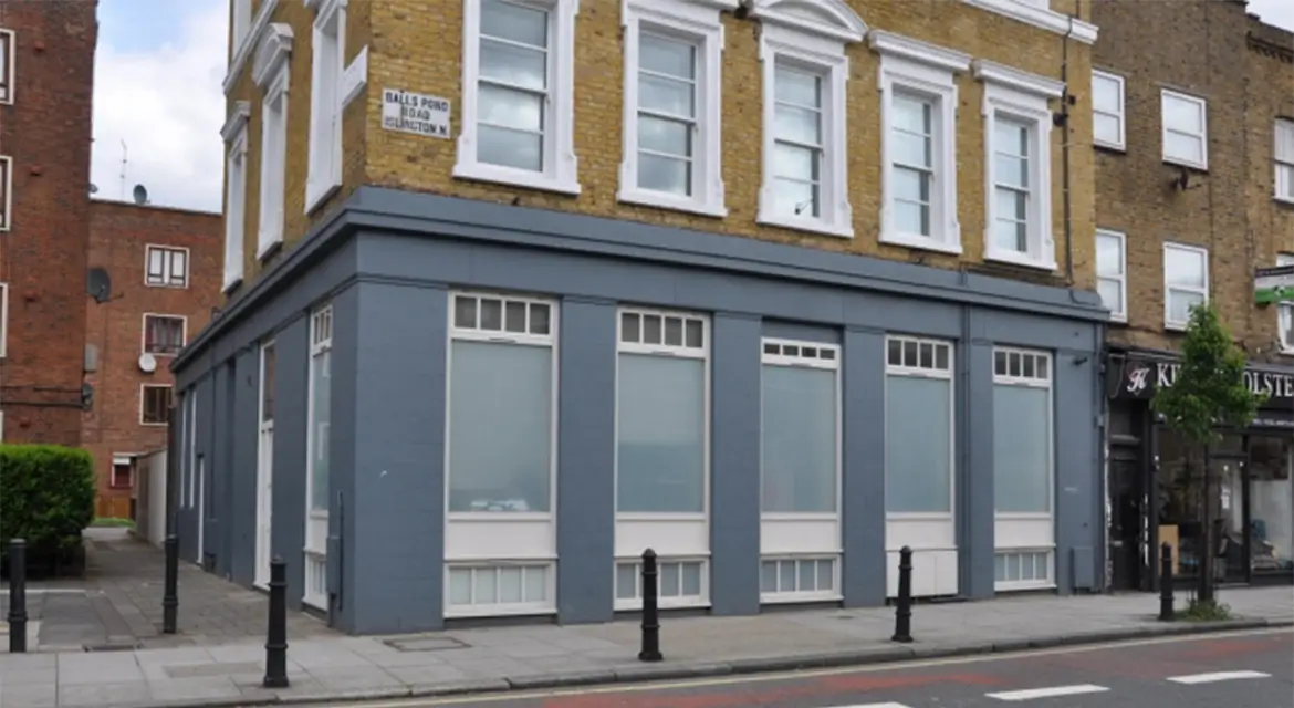 Windows, doors, and shopfront on a building on Balls Pond Road, N1, Islington, London.