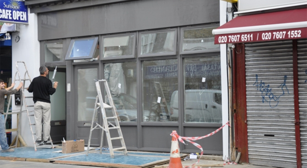 Windows, doors and shopfront on a retail shop on Brecknock Road, N7, Islington, London.