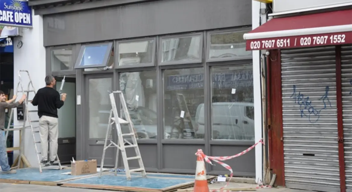 Windows, doors and shopfront on a retail shop on Brecknock Road, N7, Islington, London.
