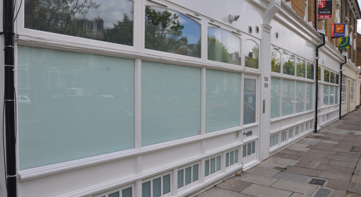 Windows, doors and shopfront on a building on Petherton Road, N5, Hackney, London.