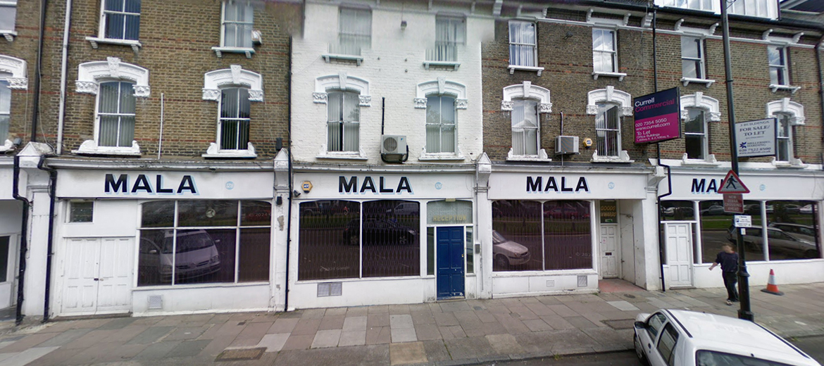 An old before-photo of windows, doors and shopfront on a building with a dark shopfront on Petherton Road, N5, Hackney, London.