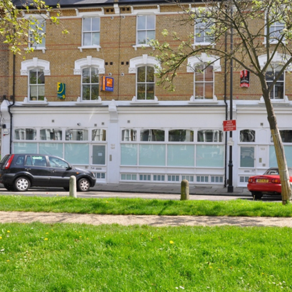 Windows, doors and shopfront on a building on Petherton Road, N5, Hackney, London.