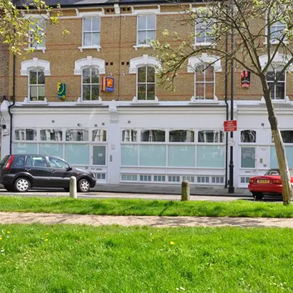 Windows, doors and shopfront on a building on Petherton Road, N5, Hackney, London.